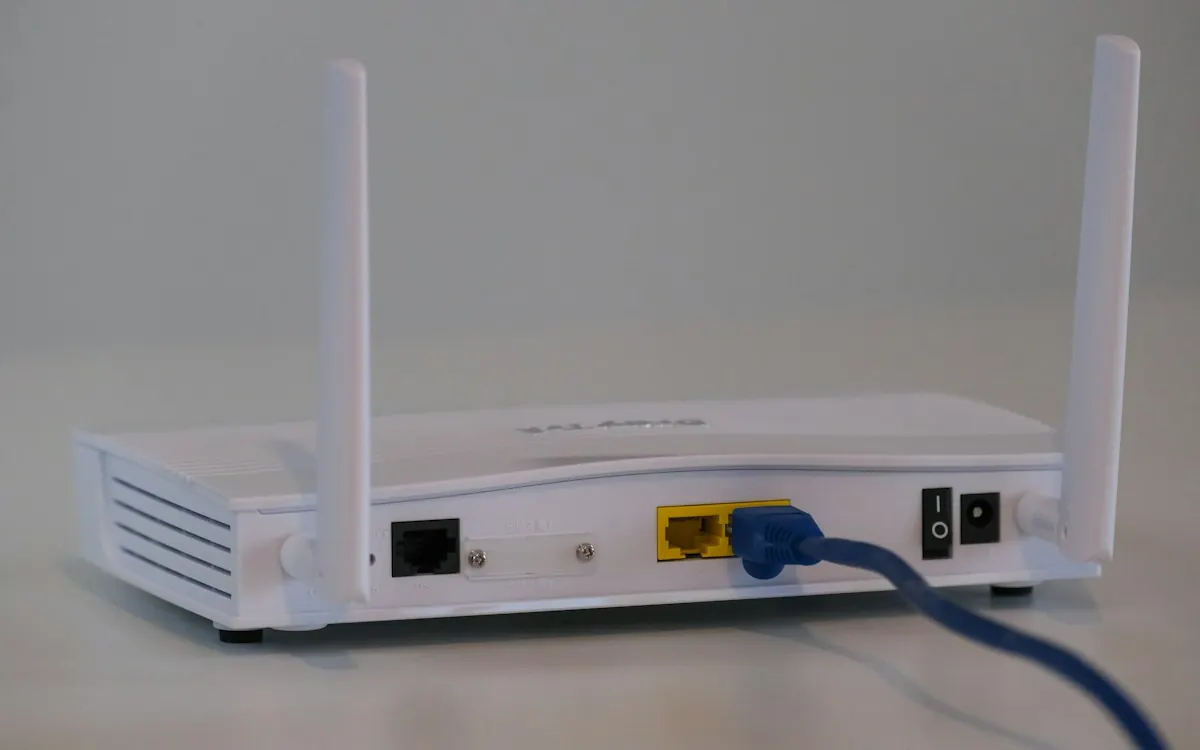 White broadband router with two aerials and a network cable plugged into the back